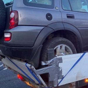 FOTÓK: Ragasztószalaggal és spaniferrel rögzítette az autót a platóra