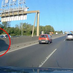 Videón, ahogy elkezd átmászni egy nő az M1-M7 elválasztó betonelemen